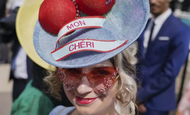 Tania Kropotina wearing an ornate hat and sunglasses looks up at the camera on the first day of the Royal Ascot horse race meeting at Ascot, England, Tuesday, June 17, 2025. (AP Photo/Alberto Pezzali)