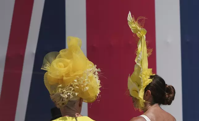 Racegoers wear ornate hast as they walk towards the Royal Enclosure on the third day of the Royal Ascot horse race meeting, traditionally called Ladies Day, at Ascot, England, Thursday, June 19, 2025. (AP Photo/kKn Cheung)