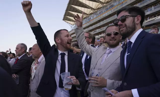 Racegoers celebrate in the public enclosure on the second day of the Royal Ascot horse race meeting at Ascot, England, Wednesday June 18, 2025. (AP Photo/Alberto Pezzali)