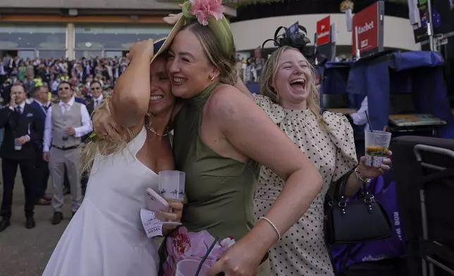 Racegoers celebrate in the public enclosure on the second day of the Royal Ascot horse race meeting at Ascot, England, Wednesday June 18, 2025. (AP Photo/Alberto Pezzali)