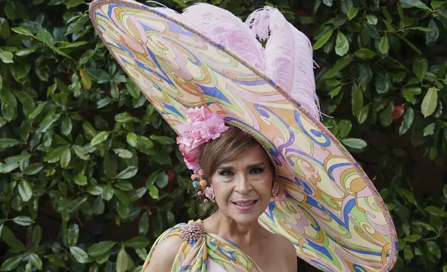 Ines Hernandez Tallaj wearing a large Muti coloured hat poses for photographs on the first day of the Royal Ascot horse race meeting at Ascot, England, Tuesday, June 17, 2025. (AP Photo/Alberto Pezzali)