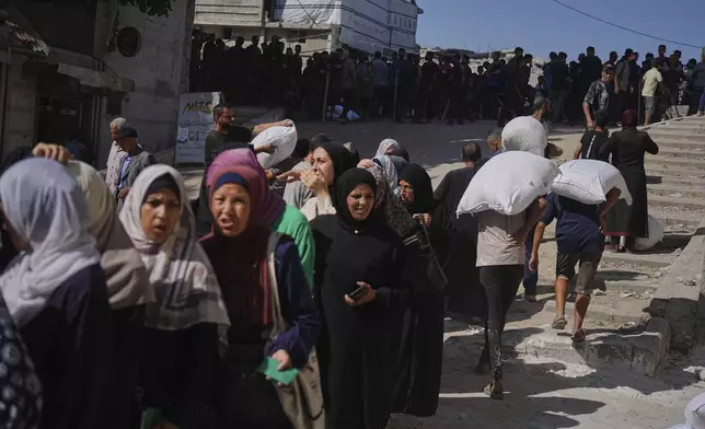Palestinians line up to receive bags of flour distributed by the World Food Programme (WFP) in Gaza City, northern Gaza Strip, on Thursday, June 26, 2025. (AP Photo/Jehad Alshrafi)