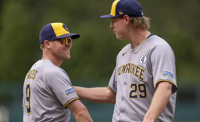 Milwaukee Brewers' Jake Bauers, left, celebrates with Trevor Megill, right, after a baseball game against the Philadelphia Phillies, Sunday, June 1, 2025, in Philadelphia. (AP Photo/Chris Szagola)