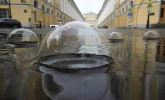Bubbles form on a puddle during rainfall in central St. Petersburg, Russia, Sunday, June 29, 2025. (AP Photo/Dmitri Lovetsky)