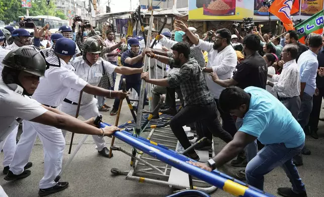 Supporters of ruling Bharatiya Janata Party break a police barricade as they march in a protest over the alleged rape of a student at the South Calcutta Law College campus on Wednesday, in Kolkata, India, Saturday, June 28, 2025. (AP Photo/Bikas Das)