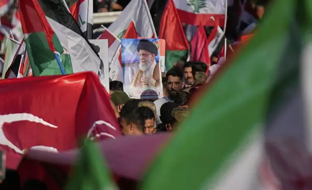 A protest holds a portrait of Iran's Supreme Leader Ayatollah Ali Khamenei during a rally to show solidarity with Iran in the Shi'ite district of Kazimiyah, in Baghdad, Iraq, Saturday, June 21, 2025. (AP Photo/Hadi Mizban)