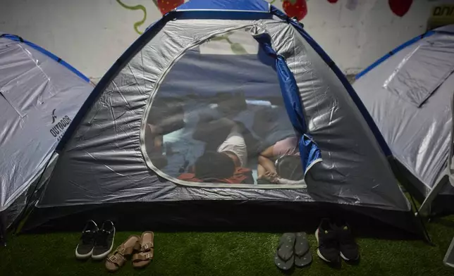 People spend the night in a public shelter as a precaution against possible Iranian missile attacks, in Tel Aviv, Israel, Saturday, June 21, 2025. (AP Photo/Ohad Zwigenberg)
