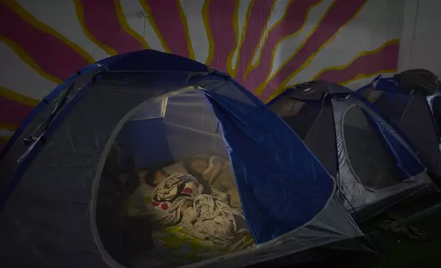 People spend the night in a public shelter as a precaution against possible Iranian missile attacks, in Tel Aviv, Israel, Saturday, June 21, 2025. (AP Photo/Ohad Zwigenberg)
