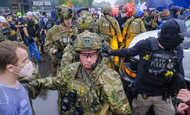 ICE, ATF, and FBI officers are seen as tensions escalate between community members and federal agents following an operation, Tuesday, June 3, 2025, in Minneapolis, Minn. (Kerem Yücel/Minnesota Public Radio via AP)