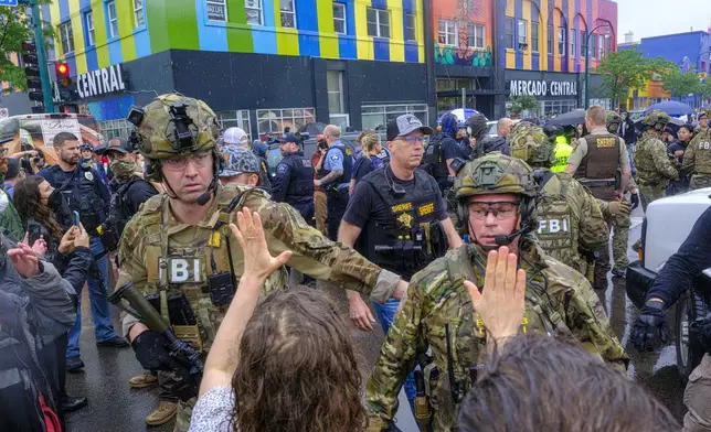 ICE, ATF, and FBI officers are seen as tensions escalate between community members and federal agents following an operation, Tuesday, June 3, 2025, in Minneapolis, Minn. (Kerem Yücel/Minnesota Public Radio via AP)
