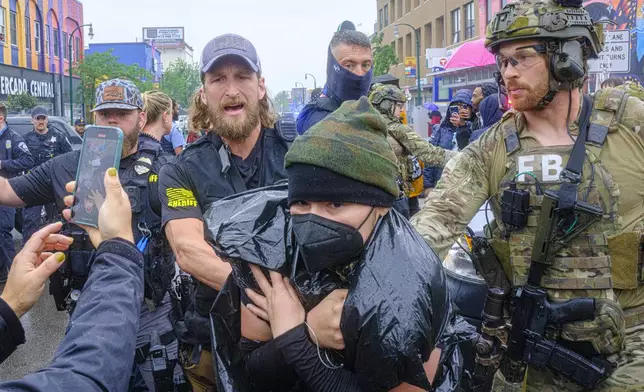 Community protesters confront law enforcement officers as federal agents conduct an operation in Minneapolis, on Tuesday, June 3, 2025. (Kerem Yücel/Minnesota Public Radio via AP)