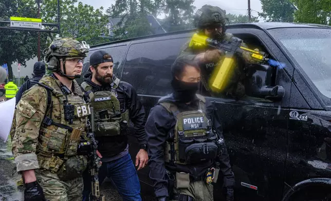 A Homeland Security Investigations (HSI) officer fires a chemical agent as federal agents conduct an operation in Minneapolis, on Tuesday, June 3, 2025. (Kerem Yücel /Minnesota Public Radio via AP)
