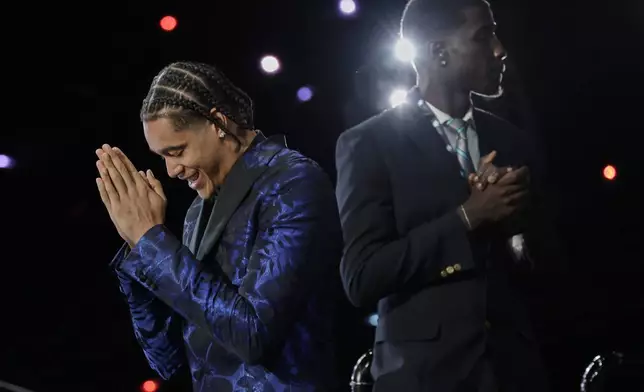 Yanic Konan Niederhauser, left, after being selected 30th by the Los Angeles Clippers in the first round of the NBA basketball draft, Wednesday, June 25, 2025, in New York. (AP Photo/Adam Hunger)