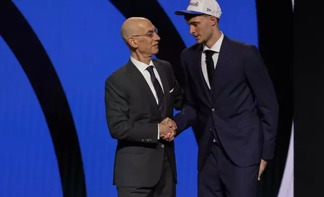 Cooper Flagg, right, shakes hands with NBA commissioner Adam Silver after being selected first overall by the Dallas Mavericks In the first round of the NBA basketball draft, Wednesday, June 25, 2025, in New York. (AP Photo/Adam Hunger)