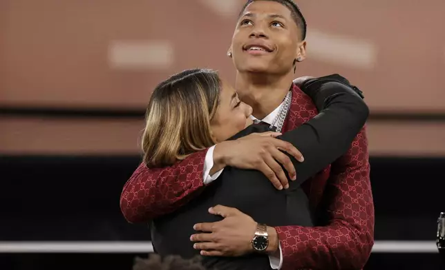 Jeremiah Fears celebrates with family after being selected seventh by the New Orleans Pelicans in the first round of the NBA basketball draft, Wednesday, June 25, 2025, in New York. (AP Photo/Adam Hunger)