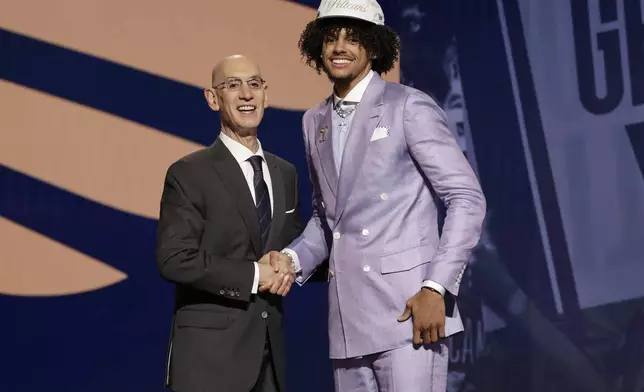 Asa Newell poses for a photo with NBA commissioner Adam Silver after being selected 23rd by the New Orleans Pelicans in the first round of the NBA basketball draft, Wednesday, June 25, 2025, in New York. (AP Photo/Adam Hunger)