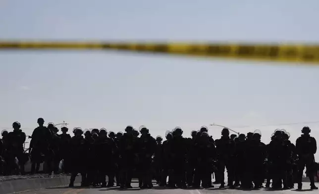 Law enforcement officers block a road during a protest on Wednesday, June 11, 2025, in Paramount, Calif. (AP Photo/Jae C. Hong)