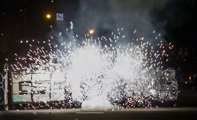 Fireworks explode during protests over the Trump administration's immigration raids in Los Angeles, Monday, June 9, 2025. (AP Photo/Ethan Swope)
