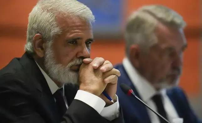 Dr. Robert Malone, left, listens during a meeting of the Advisory Committee in Immunization Practices at the CDC, Wednesday, June 25, 2025, in Atlanta. (AP Photo/Mike Stewart)