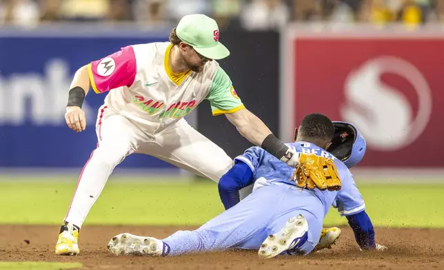 San Diego Padres second baseman Jake Cronenworth, left, tries to tag Kansas City Royals' Tyler Tolbert stealing second, in the ninth inning of a baseball game, Friday, June 20, 2025, in San Diego. (AP Photo/Tony Ding)