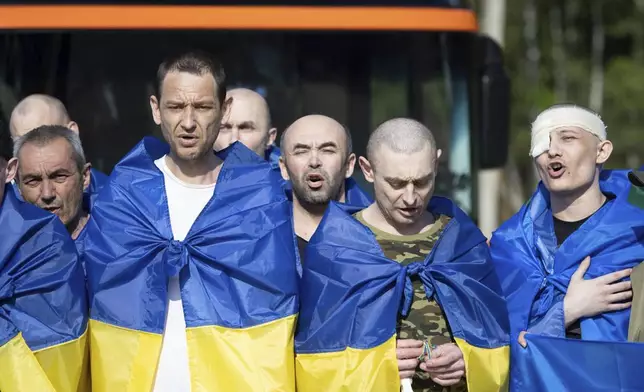 In this photo provided by the Ukrainian Presidential Press Office, Ukrainian soldiers react after returning from captivity during a prisoners' exchange between Russia and Ukraine, in Chernyhiv region, Ukraine, Tuesday, June 10, 2025. (Ukrainian Presidential Press Office via AP)