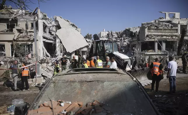 Israeli security forces inspect the site of homes destroyed by a missile fired from Iran, in Rishon Lezion, Israel, on Saturday, June 14, 2025. (AP Photo/Ohad Zwigenberg)