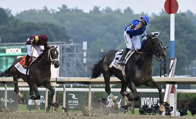 Jockey Junior Alvarado reacts aboard Sovereignty (2), as he crosses the finish line ahead of Journalism (7), with jockey Umberto Rispoli up, to win the 157th running of the Belmont Stakes horse race, Saturday, June 7, 2025, in Saratoga Springs, N.Y. (AP Photo/Jessica Hill)