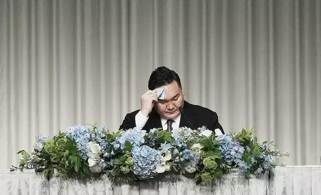 Hakuho Sho, a retired "yokozuna" or grand champion of sumo Hakuho, wipes his face during a press conference in Tokyo, Monday, June 9, 2025, to deliver a farewell message following the reported acceptance of his resignation and to outline his future plans. (AP Photo/Eugene Hoshiko)