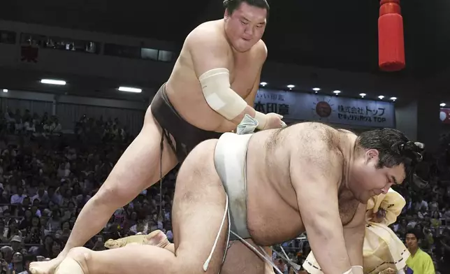 FILE - Mongolian grand champion Hakuho, left, topples champion Takayasu to win their bout during the Nagoya Grand Sumo Tournament in Nagoya, central Japan, Friday, July 21, 2017. (Yoshiaki Sakamoto/Kyodo News, File)