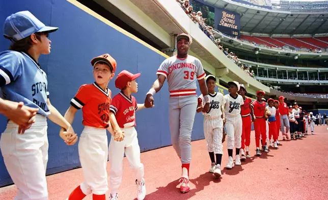 FILE - Cincinnati Reds Dave Parker joins hands with Pittsburgh area little leaguers during a pre-game Hands Across America celebration in Three Rivers Stadium in Pittsburgh, May 25, 1986. (AP Photo/Gene J. Puskar, File)