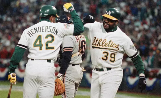 FILE - Oakland Athletics Dave Henderson (42) greets teammate Dave Parker (39) after Parker hit a home run against the San Francisco Giants in the third inning in Game 1 of baseball's World Series, Oct. 14, 1989, in Oakland, Calif. (AP Photo/Lenny Ignelzi, File)