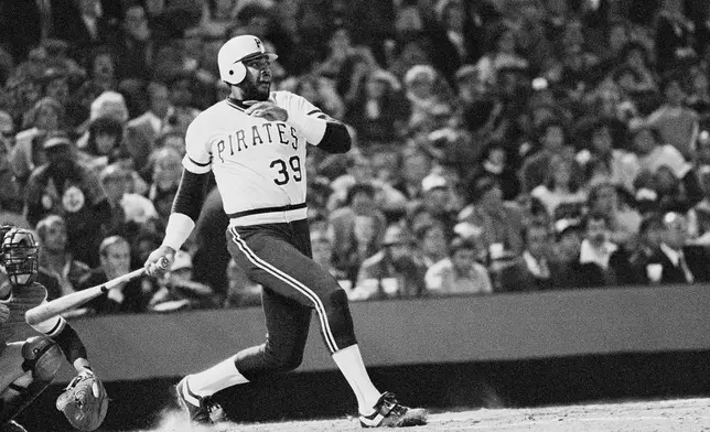FILE - Pittsburgh Pirates Dave Parker smashes ball that took a bad hop in front of Orioles Rich Dauer and sailed into right field scoring Omar Moreno and the Bucs first run in the seventh inning in Game 6 in baseball's World Series game, Oct. 16, 1979, in Baltimore. (AP Photo/File)