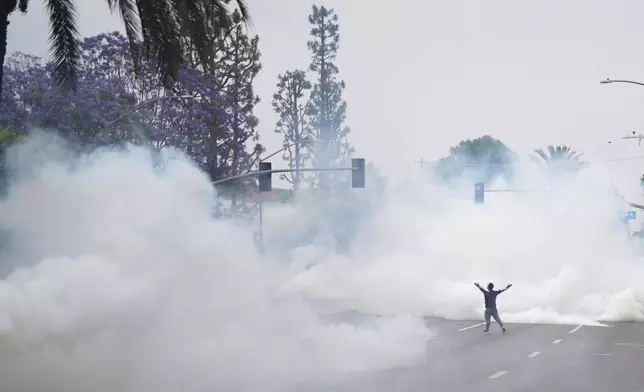 Tear gas fills the street as protesters confront Border Patrol personnel during a demonstration over the dozens detained in an operation by federal immigration authorities a day earlier, in Paramount, Calif., on Saturday, June 7, 2025. (AP Photo/Eric Thayer)