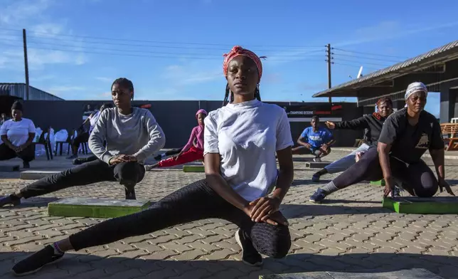 Community members participate in a yoga class at Socialite Bar in Chitungwiza on the outskirts of Harare, Zimbabwe, Saturday, June 14, 2025. (AP Photo/Aaron Ufumeli)