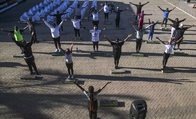 Community members participate in a yoga class at Socialite Bar in Chitungwiza on the outskirts of Harare, Zimbabwe, Saturday, June 14, 2025. (AP Photo/Aaron Ufumeli)