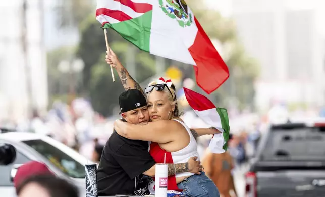 Roxy Sotu, left, and her fiancée Athena Godoy hug during a "No Kings" protest Saturday, June 14, 2025, in Los Angeles. (AP Photo/Noah Berger)