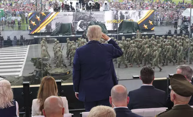 President Donald Trump, center, salutes passing troops during a parade to honor the Army's 250th anniversary, coinciding with Trump's 79th birthday, Saturday, June 14, 2025, in Washington. (Doug Mills/The New York Times via AP, Pool)