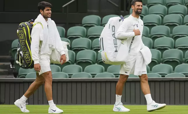Novak Djokovic of Serbia, right, and Carlos Alcaraz of Spain, left, arrive for a practice session on Centre Court at the All England Lawn Tennis and Croquet Club, ahead of the Wimbledon Championships in London, Thursday, June 26, 2025. (AP Photo/Kirsty Wigglesworth)