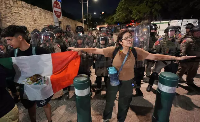 Anti ICE protesters gather near the Alamo as Texas state troopers keep watch in downtown San Antonio, Wednesday, June 11, 2025. (AP Photo/Eric Gay)