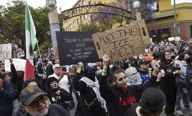 People hold a vigil at Fruitvale Station in Oakland, Calif. to show solidarity with demonstrations against ICE raids, on Tuesday, June 10, 2025. (Santiago Mejia/San Francisco Chronicle via AP)