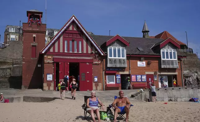 People enjoy the hot weather at Cullercoats Beach in North Shields, England, Friday, June 20, 2025. (Owen Humphreys/PA via AP)