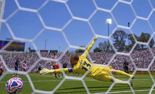 Atletico Madrid's goalkeeper Jan Oblak fails to block a shot by Paris Saint-Germain's Fabian Ruiz to score the opening goal during the Club World Cup group B soccer match between PSG and Atletico Madrid, in Pasadena, Calif., Sunday, June 15, 2025. (AP Photo/Mark J. Terrill)