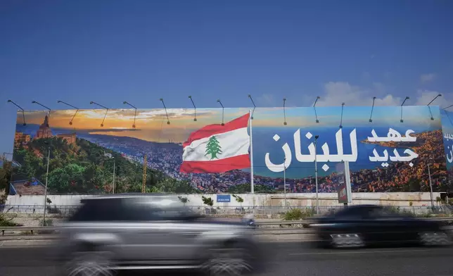 Cars pass in front of a billboard that reads, in Arabic, "A new era for Lebanon," in Beirut, Lebanon, May 28, 2025. (AP Photo/Hussein Malla)