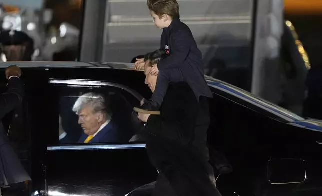 FILE - Elon Musk carries his son X Æ A-Xii as they arrives on Air Force One with President Donald Trump, left, at Miami International Airport, April 12, 2025, in Miami, Fla. (AP Photo/Manuel Balce Ceneta, File)