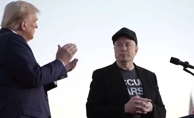 FILE - Republican presidential nominee former President Donald Trump, left, claps as Tesla and SpaceX CEO Elon Musk prepares to depart after speaking at a campaign event at the Butler Farm Show, on Oct. 5, 2024, in Butler, Pa. (AP Photo/Alex Brandon, File)