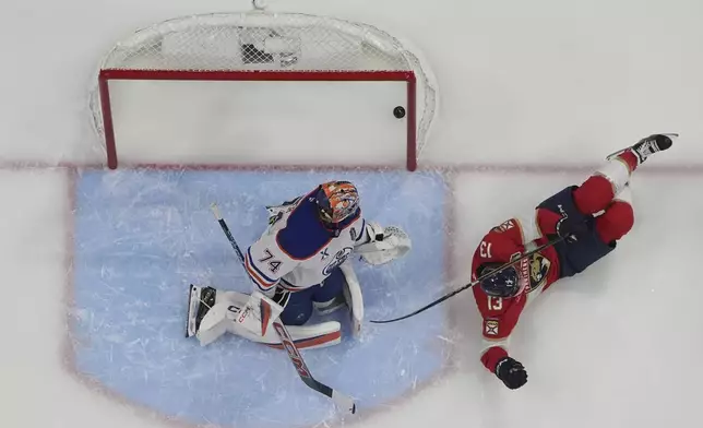 Florida Panthers center Sam Reinhart (13) slides on the ice after scoring a goal against Edmonton Oilers goaltender Stuart Skinner (74) during the first period of Game 6 of the NHL hockey Stanley Cup Final Wednesday, June 18, 2025, in Sunrise, Fla. (AP Photo/Lynne Sladky)