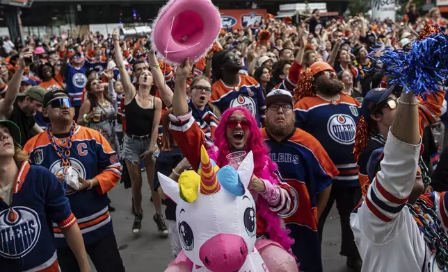 Fans cheer at an outdoor watch party as the Edmonton Oilers take on the Florida Panthers during Game 6 of the NHL hockey Stanley Cup Final, in Edmonton, Alberta, Tuesday, June 17, 2025. (Jason Franson/The Canadian Press via AP)