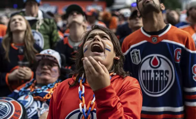 A fan reacts to the Florida Panthers scoring a goal against the Edmonton Oilers at an outdoor watch party during Game 6 of the NHL hockey Stanley Cup Final, in Edmonton, Alberta, Tuesday, June 17, 2025. (Jason Franson/The Canadian Press via AP)
