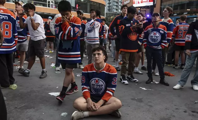 Fans react to the Edmonton Oilers losing to the Florida Panthers in Game 6 of the NHL hockey Stanley Cup Final during an outdoor viewing party in Edmonton, Alberta, Tuesday, June 17, 2025. (Jason Franson/The Canadian Press via AP)