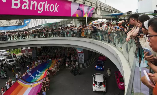 LGBTQ+ community members hold a rainbow flag in its Pride Parade in Bangkok, Thailand, Sunday, June 1, 2025. (AP Photo/Sakchai Lalit)